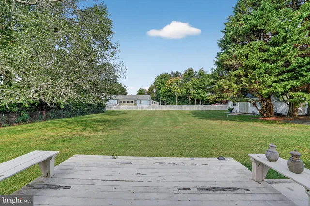 a front view of house with a garden and trees