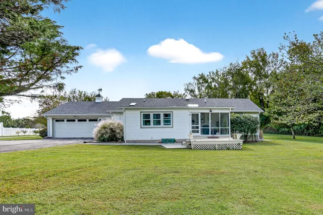 a view of a house with a big yard and palm trees