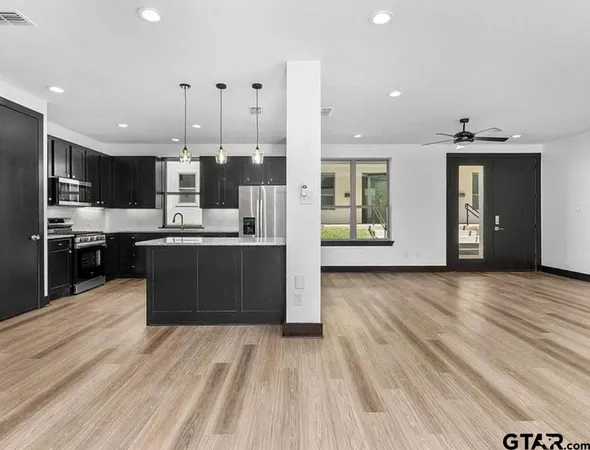 a kitchen with stainless steel appliances kitchen island wooden cabinets and granite counter tops