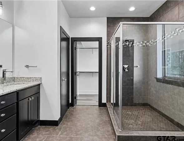 a bathroom with a granite countertop sink mirror and shower