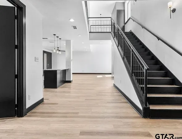 a view of a hallway with wooden floor and staircase