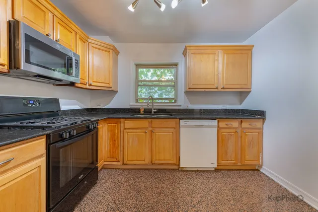 a kitchen with stainless steel appliances granite countertop a stove a sink and a microwave