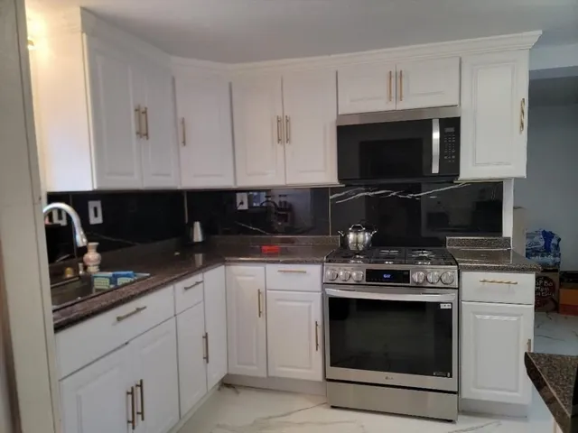 a kitchen with cabinets stainless steel appliances and a sink