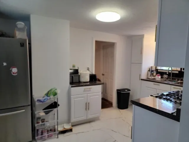 a kitchen with stainless steel appliances granite countertop a refrigerator and a stove