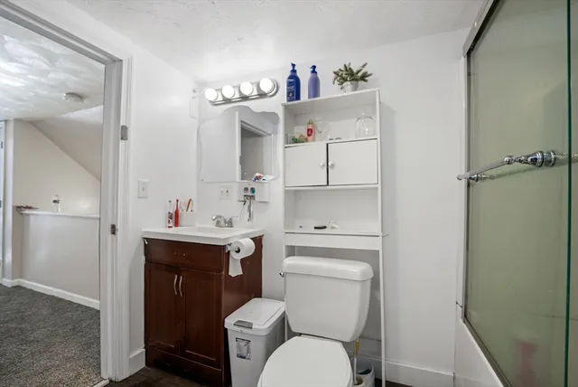 a bathroom with a toilet sink vanity and mirror