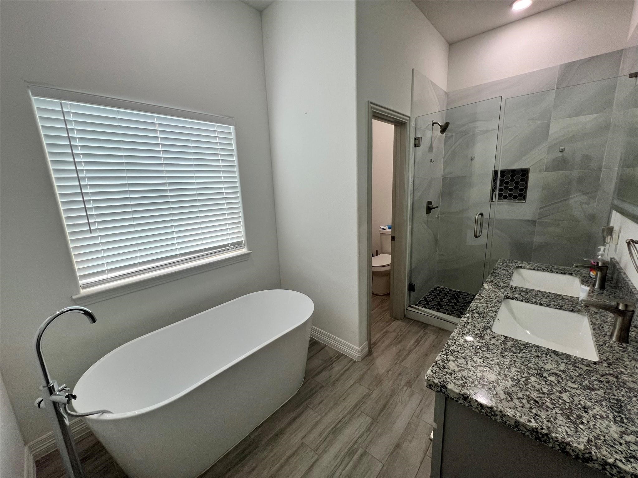 3407 Sakowitz Street, Unit B Houston, TX 77026 - Photo 8 of 23 a bathroom with a granite countertop sink a toilet and shower