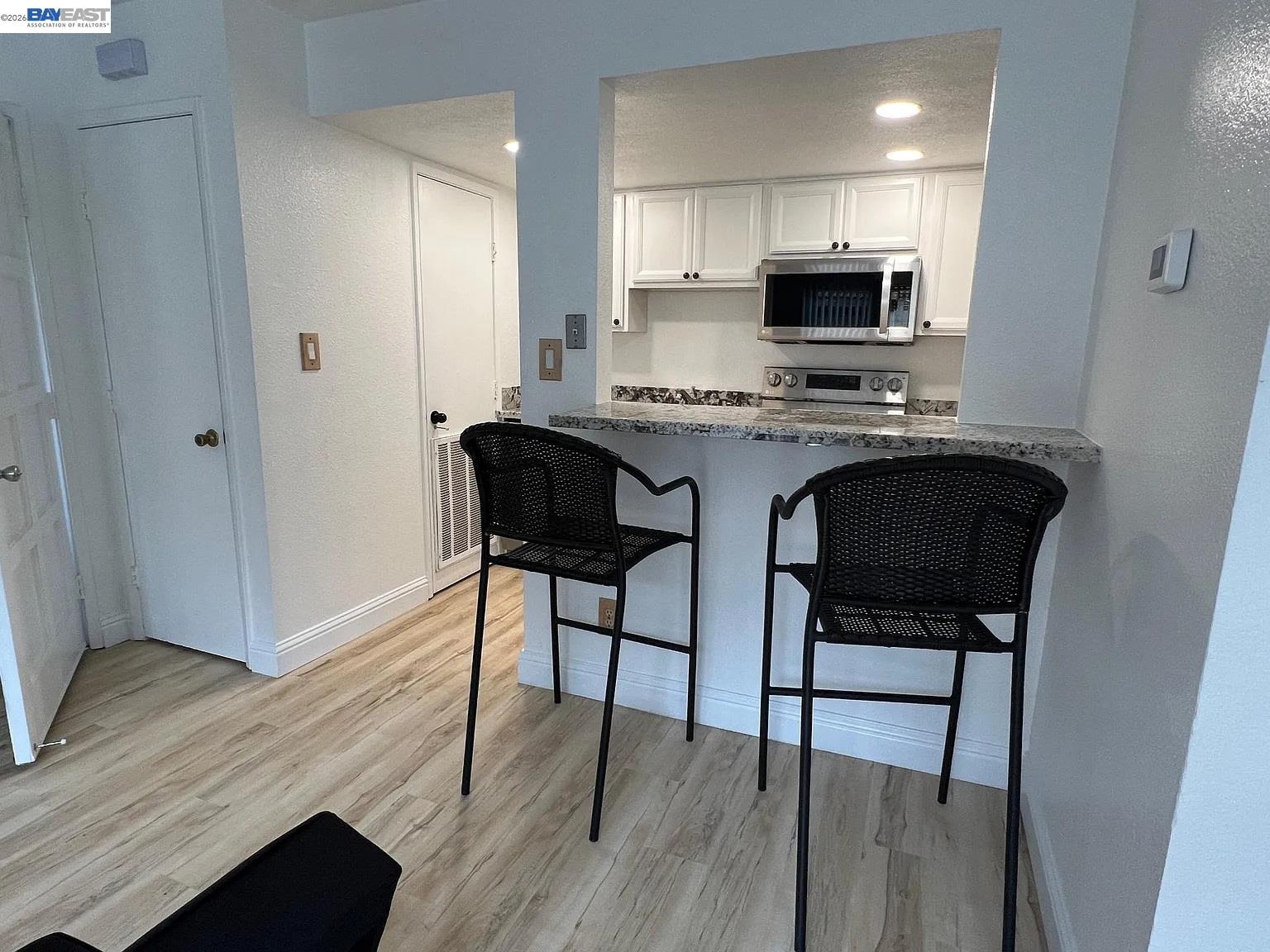 a kitchen with stainless steel appliances granite countertop a stove top oven a sink dishwasher and a microwave