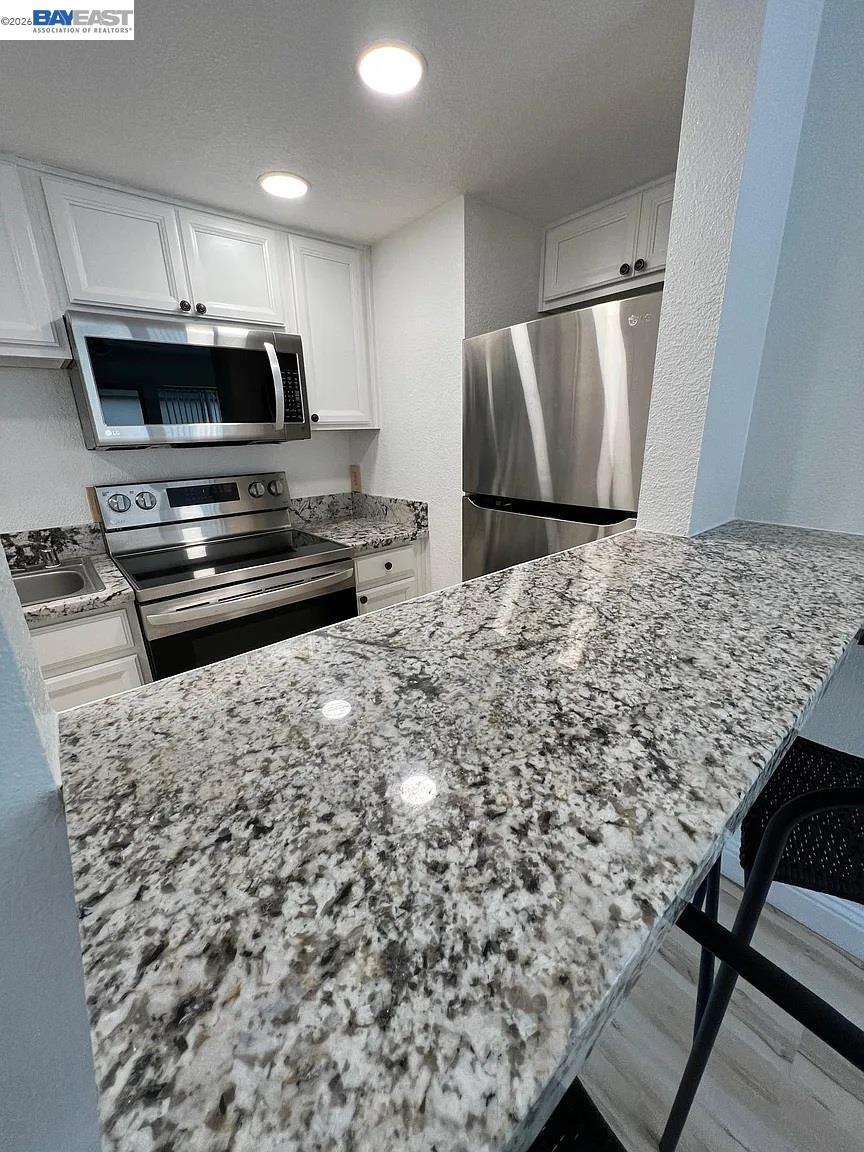 3701 Colonial Drive, Unit 36 Modesto, CA 95356 - Photo 9 of 36 a kitchen with a stove a refrigerator and a fireplace