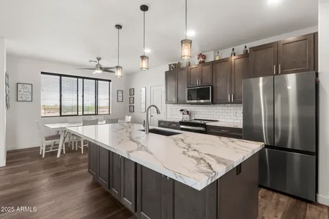 a kitchen with stainless steel appliances granite countertop a sink a stove and a refrigerator