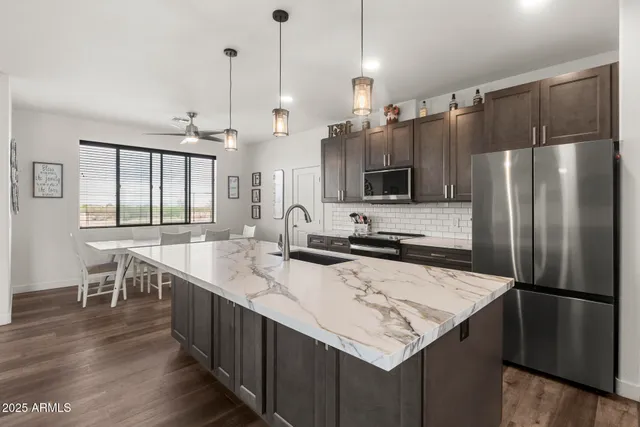 a kitchen with stainless steel appliances granite countertop a sink a stove and a refrigerator