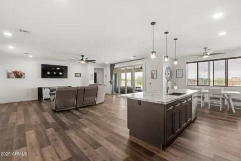 a large kitchen with stainless steel appliances kitchen island a large counter top and a wooden floors
