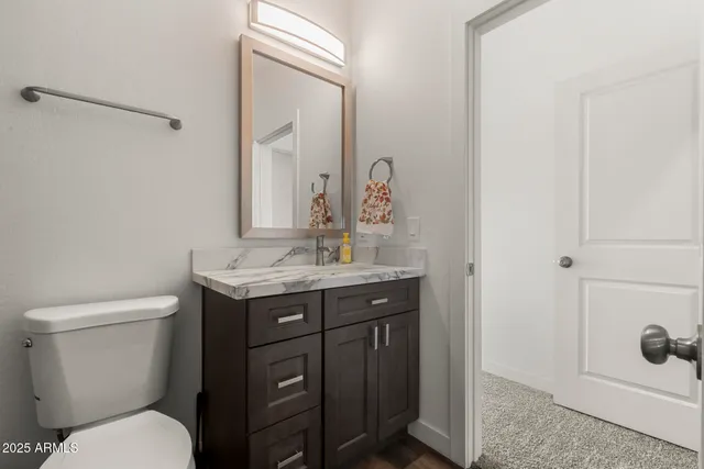 a bathroom with a granite countertop toilet sink a mirror a bathtub and shower