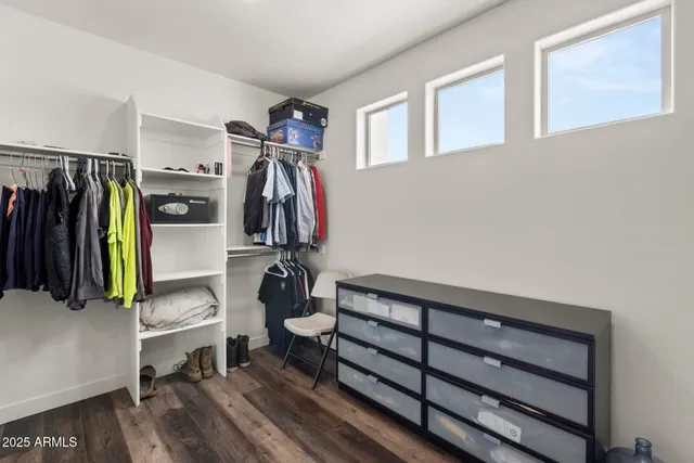a view of walk in closet with clothes and shoes