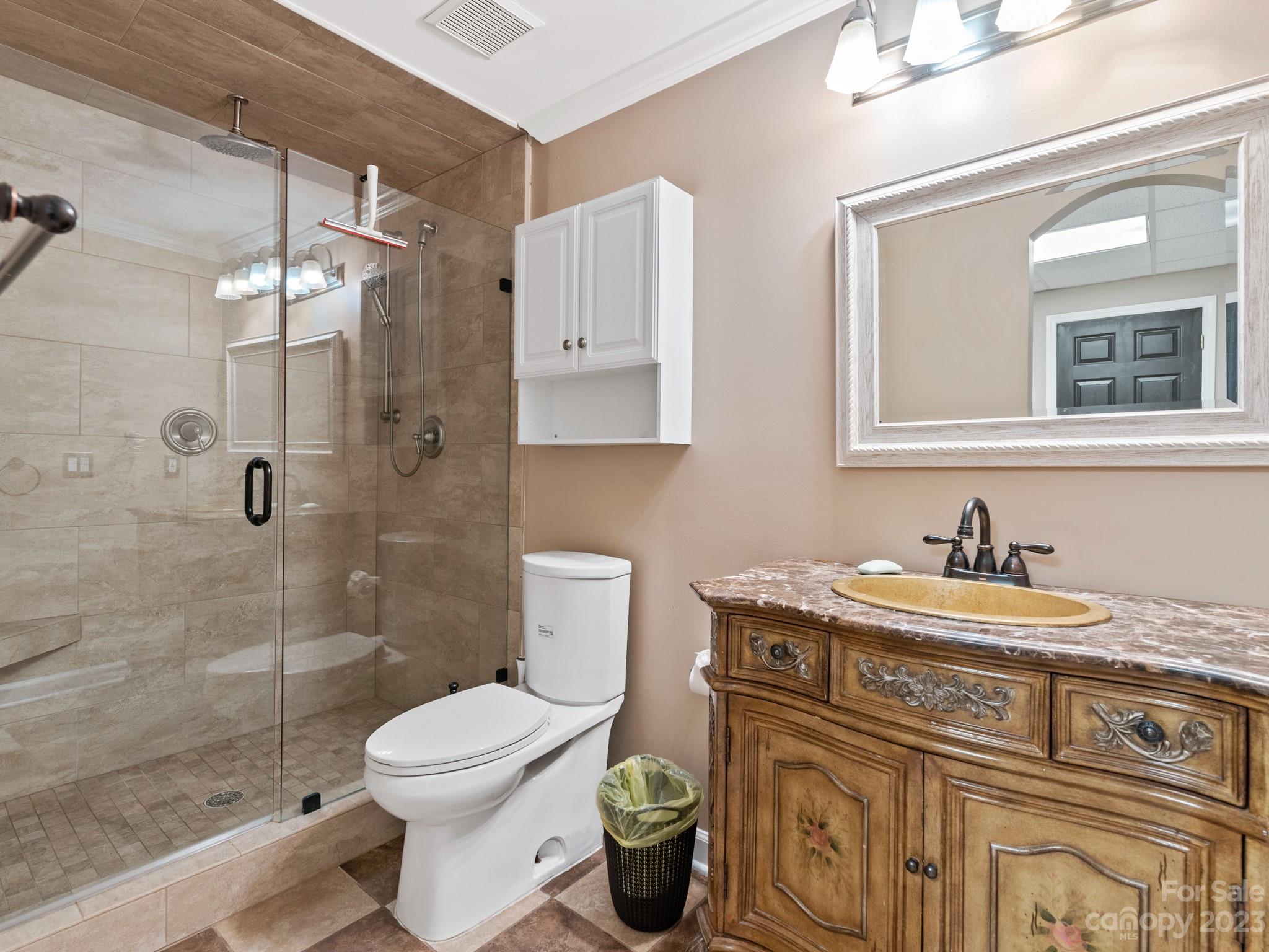 684 Beacon Knoll Lane Fort Mill, SC 29708 - Photo 34 of 46 a bathroom with a granite countertop toilet a sink a mirror a bathtub and shower
