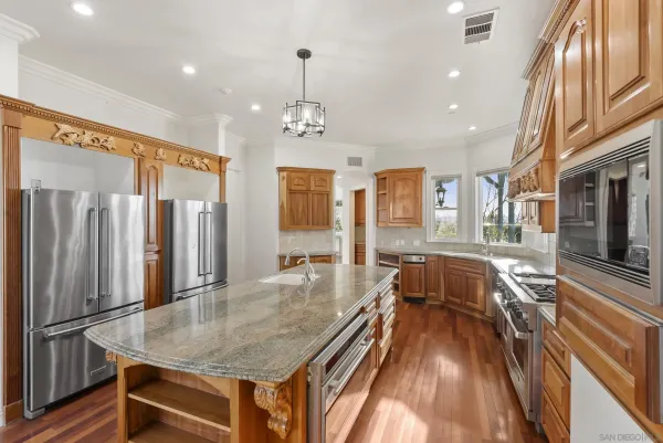 a dining room with wooden floor a chandelier a wooden table and chairs