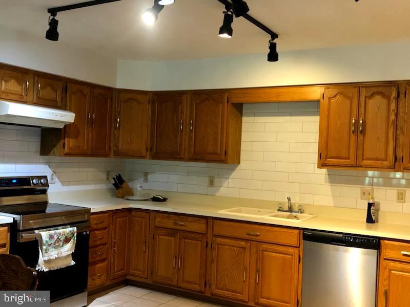 181 Grove Farm Road Front Royal, VA 22630 - Photo 18 of 35 a kitchen with stainless steel appliances granite countertop a sink a stove and a wooden cabinets
