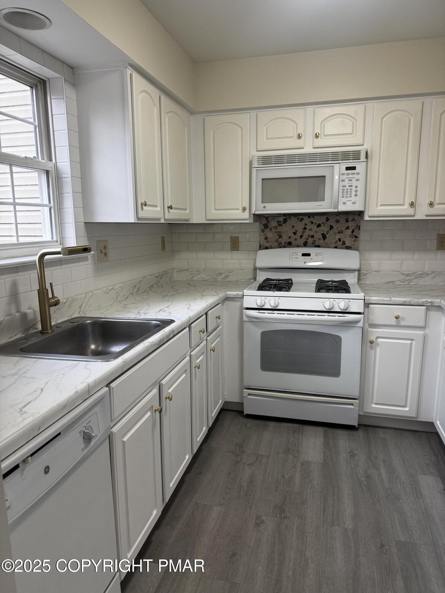 63 Ridgeview Circle, Unit A East Stroudsburg, PA 18302 - Photo 4 of 13 a white kitchen with granite countertop a stove top oven a sink and dishwasher