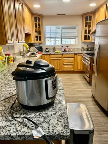 a kitchen with stainless steel appliances granite countertop a sink stove and refrigerator