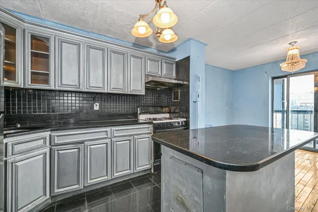 a kitchen with granite countertop a sink stainless steel appliances cabinets and a counter top space