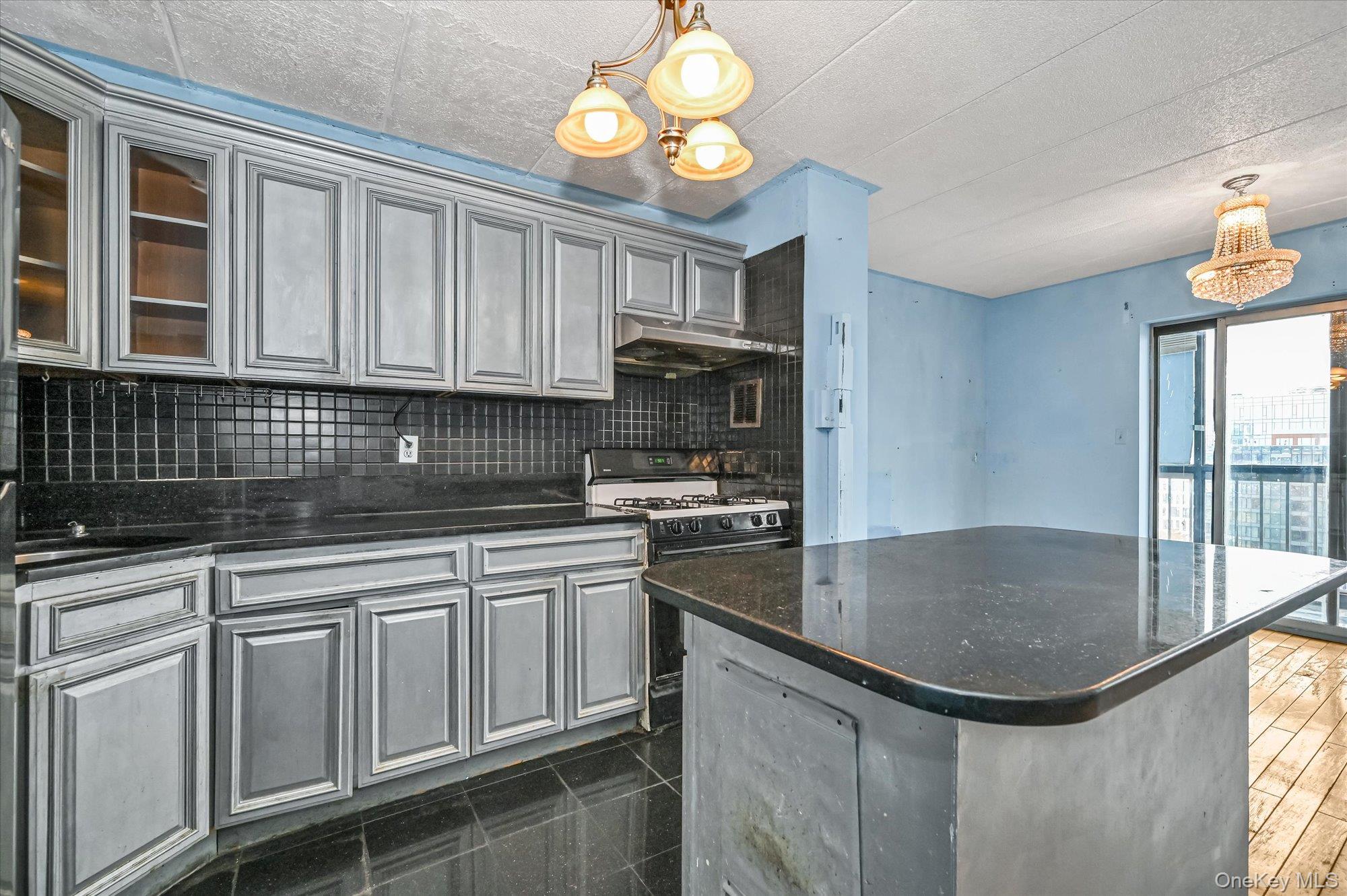 136-75 37th Avenue, Unit PH B Queens, NY 11354 - Photo 3 of 17 a kitchen with granite countertop a sink stainless steel appliances cabinets and a counter top space