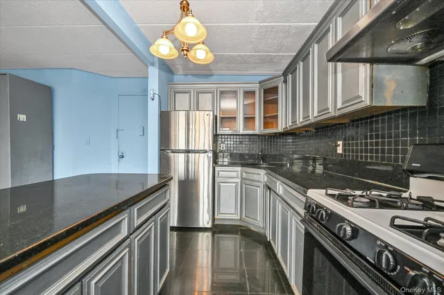 a kitchen with stainless steel appliances granite countertop a stove a refrigerator and a sink