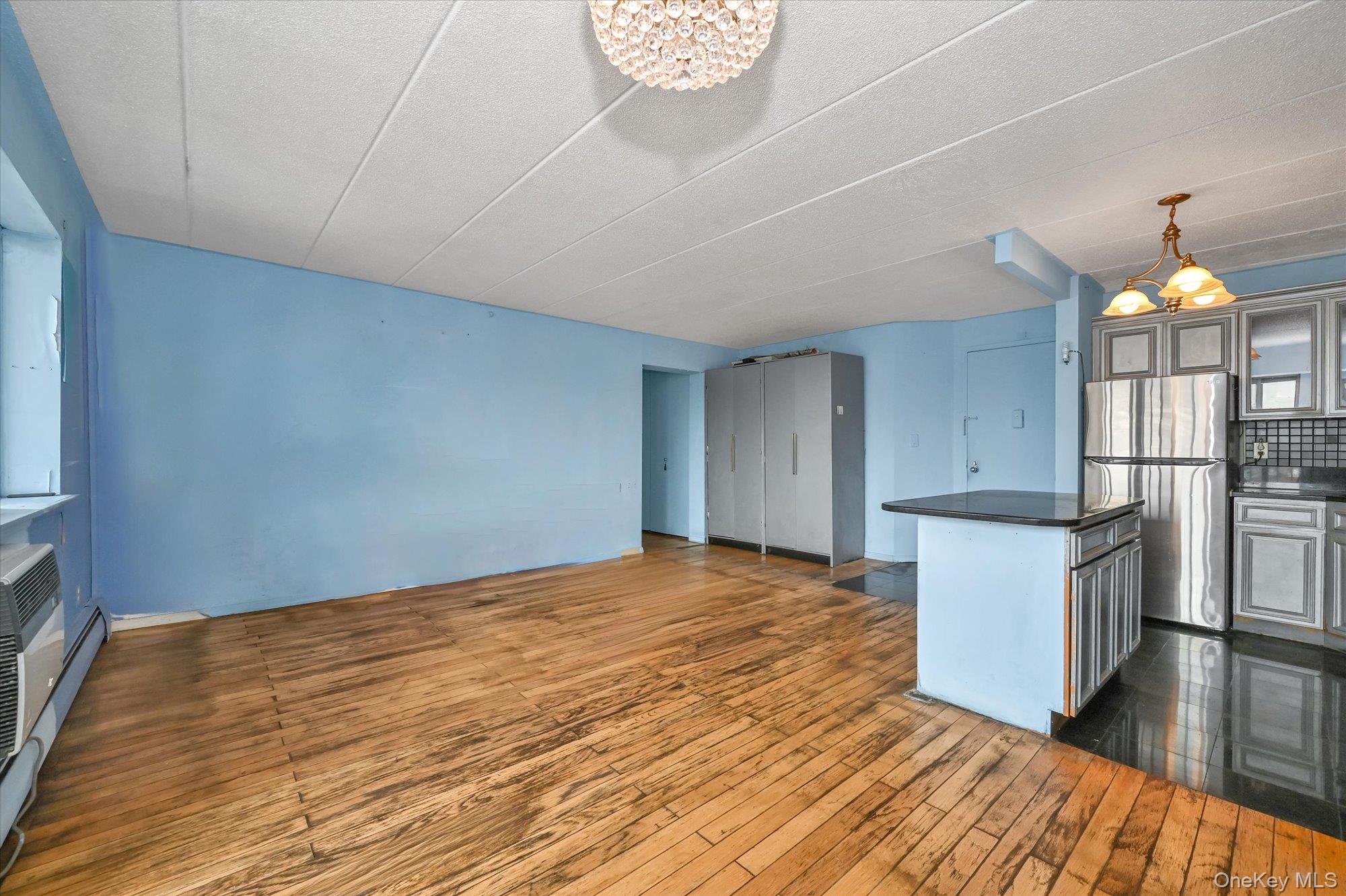 136-75 37th Avenue, Unit PH B Queens, NY 11354 - Photo 17 of 17 a big room with wooden floor and kitchen view