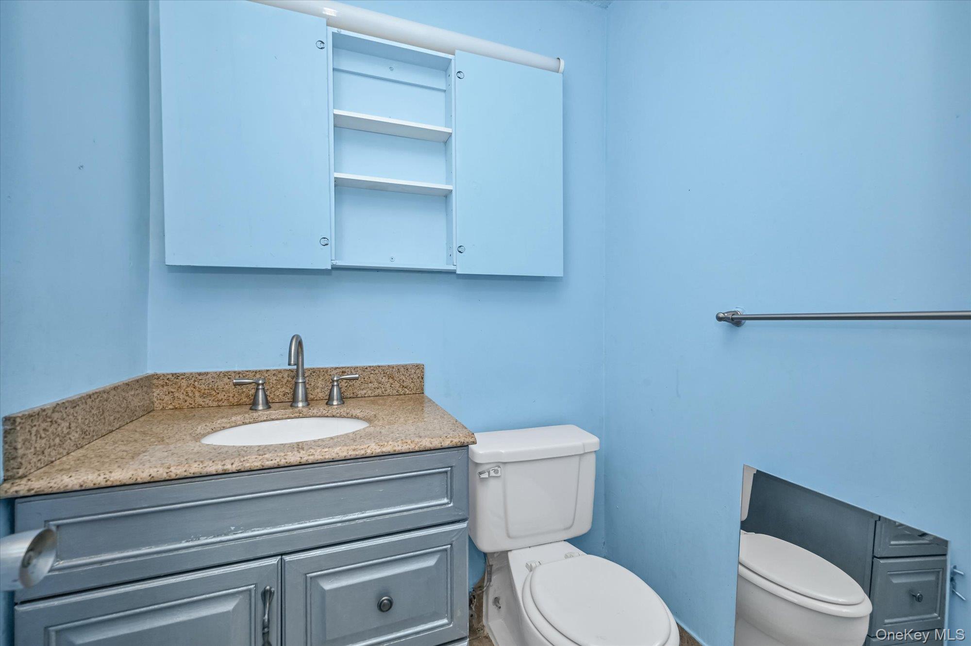 136-75 37th Avenue, Unit PH B Queens, NY 11354 - Photo 6 of 17 a bathroom with a toilet sink and mirror