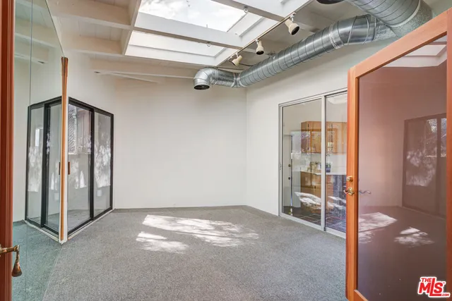 a view of a hallway with wooden floor and cabinet