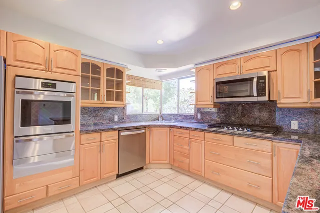 a kitchen with stainless steel appliances granite countertop a refrigerator and a sink