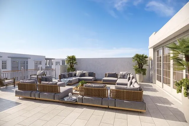 a view of a terrace with couches and lounge chairs
