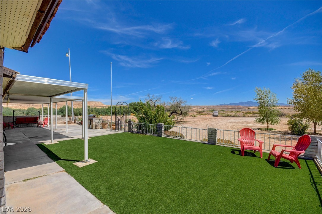 1920 Bowman Road Logandale, NV 89021 - Photo 2 of 68 An expansive concrete patio connects to a level lawn overlooking wide open desert views.