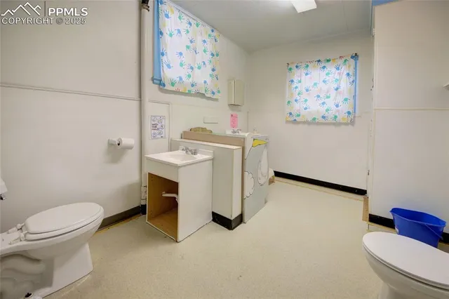 a bathroom with a toilet a sink and a shower curtain