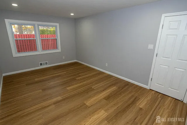 a view of empty room with wooden floor