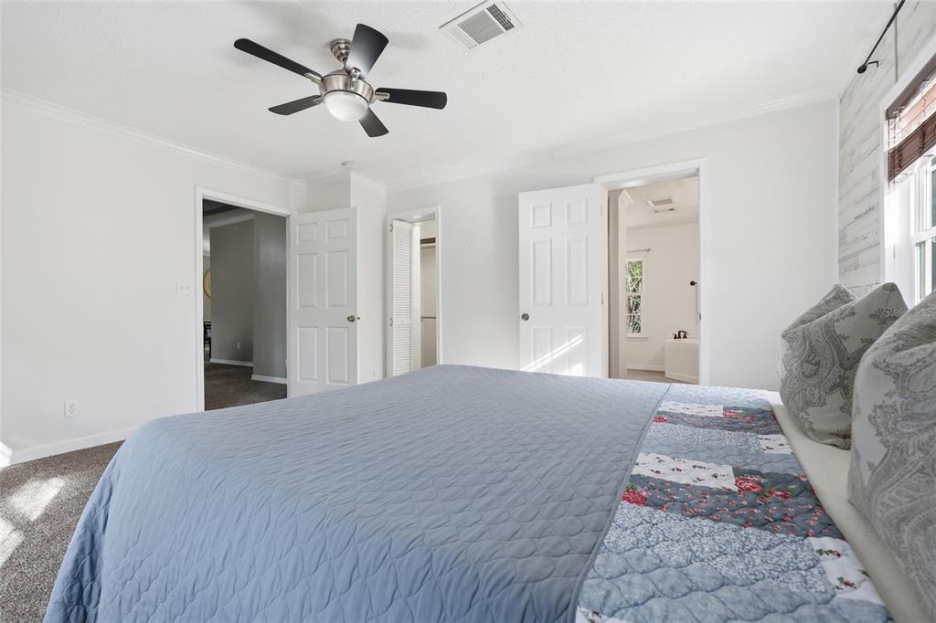 269 Southwest Backwoods Glen Fort White, FL 32038 - Photo 15 of 31 a bedroom with a large bed and a chandelier