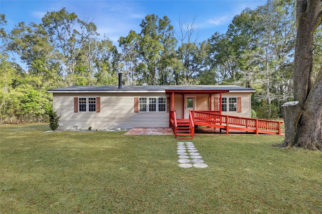 269 Southwest Backwoods Glen Fort White, FL 32038 - Photo 2 of 31 a front view of house with yard barbeque and outdoor seating