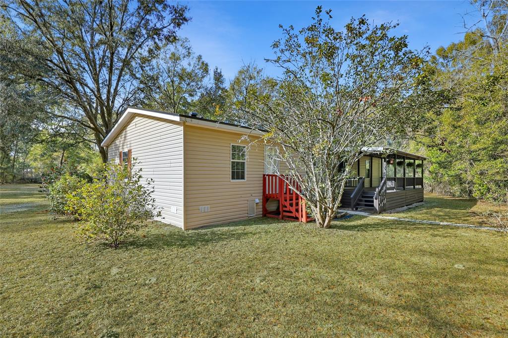 269 Southwest Backwoods Glen Fort White, FL 32038 - Photo 26 of 31 a view of backyard with large trees and flower plants