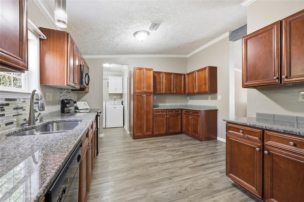 269 Southwest Backwoods Glen Fort White, FL 32038 - Photo 7 of 31 a kitchen with stainless steel appliances granite countertop a sink stove and refrigerator