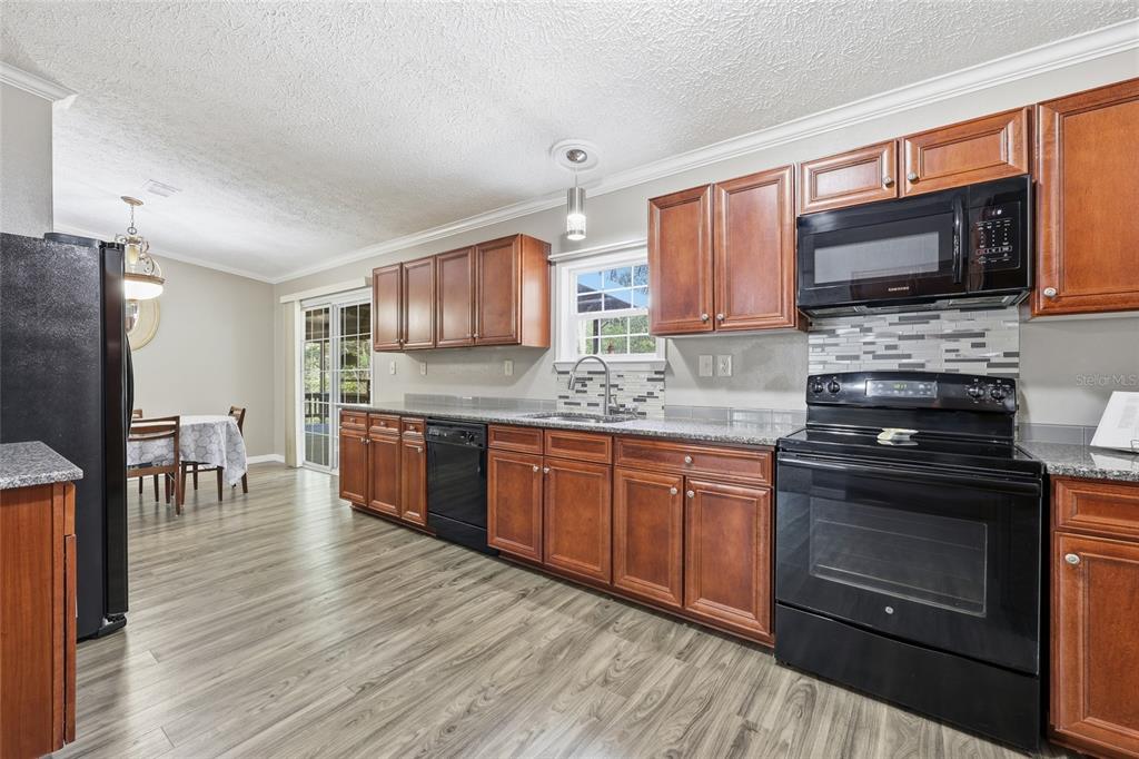 269 Southwest Backwoods Glen Fort White, FL 32038 - Photo 9 of 31 a kitchen with stainless steel appliances granite countertop a stove microwave and sink