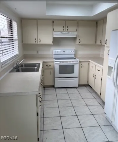 a kitchen with a stove sink and cabinets