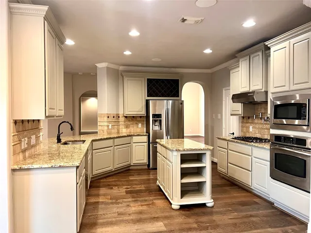 a kitchen with stainless steel appliances a refrigerator sink and microwave