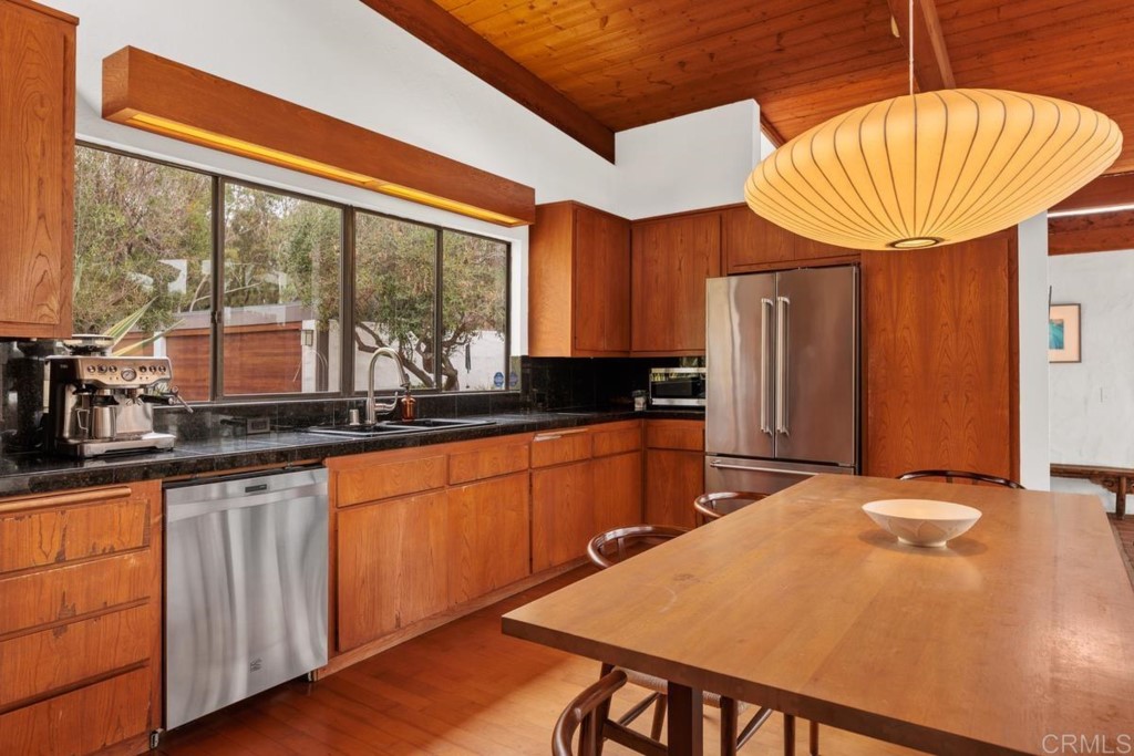 3533 Dove Hollow Road Encinitas, CA 92024 - Photo 11 of 32 a kitchen with stainless steel appliances granite countertop a sink a refrigerator and a wooden cabinets
