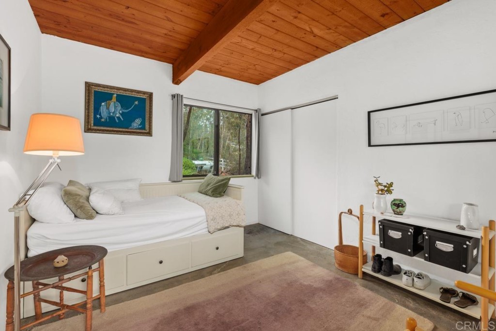 3533 Dove Hollow Road Encinitas, CA 92024 - Photo 18 of 32 a bedroom with a bed and a lamp on the dresser