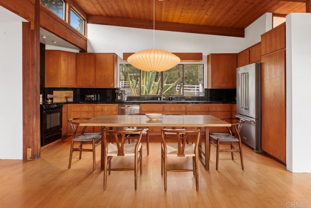 3533 Dove Hollow Road Encinitas, CA 92024 - Photo 9 of 32 a dining room with stainless steel appliances a dining table chairs and a refrigerator