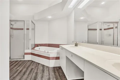 a spacious bathroom with a double vanity sink a mirror and a bathtub