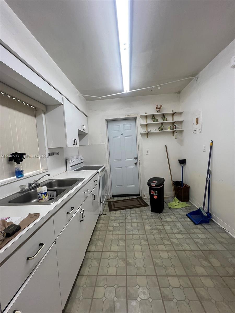 5561 Southwest 5th Terrace Miami, FL 33134 - Photo 17 of 39 a kitchen with a sink a stove and cabinets