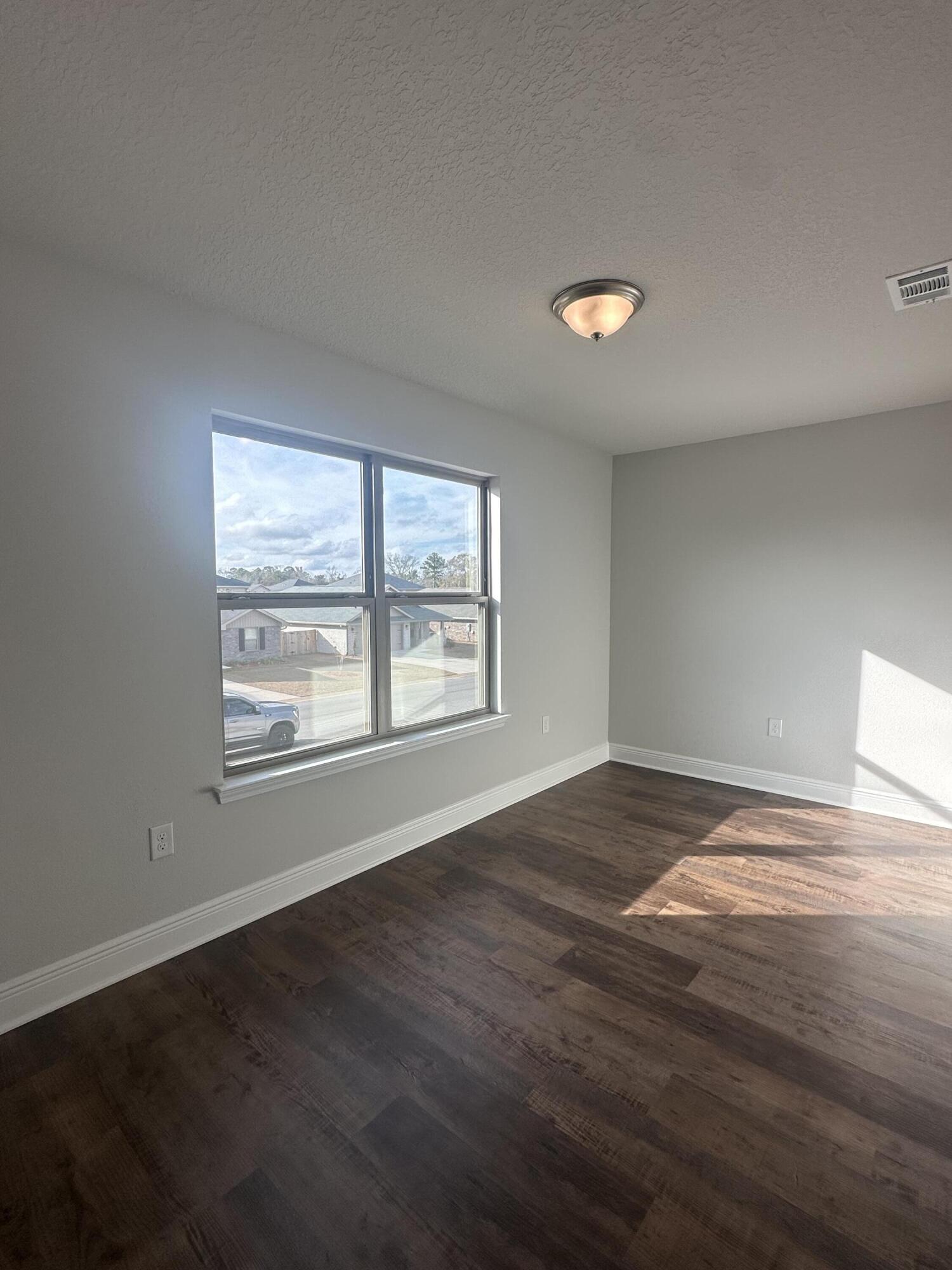 193 Ridgeway Circle Crestview, FL 32536 - Photo 19 of 33 a view of an empty room with wooden floor and a window