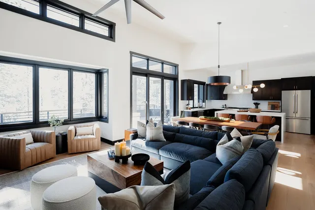 a living room with furniture kitchen view and a large window