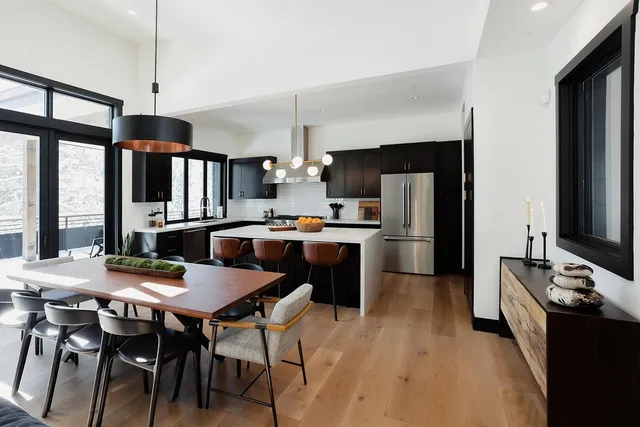 a kitchen with a table chairs refrigerator and cabinets