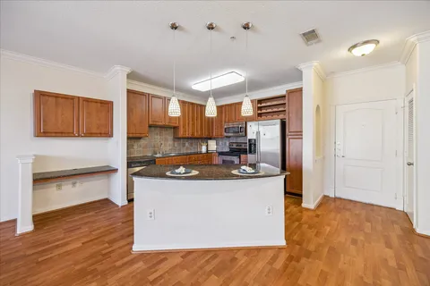 a kitchen with stainless steel appliances granite countertop a refrigerator a stove top oven a sink and dishwasher