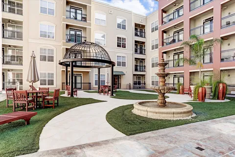 a front view of a building with a garden and plants